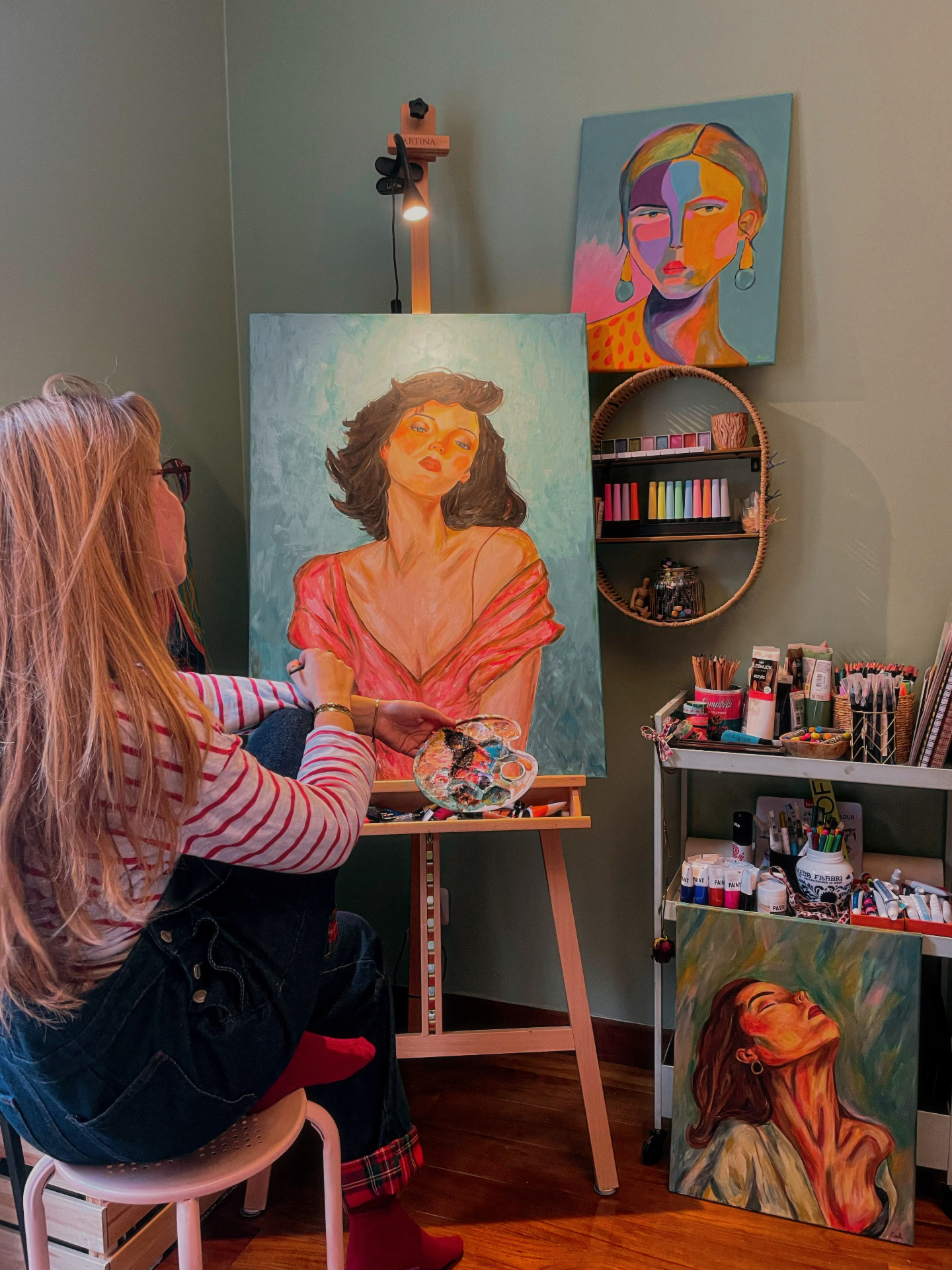 Oneli dans son atelier, une toile de portrait sur le chevalet